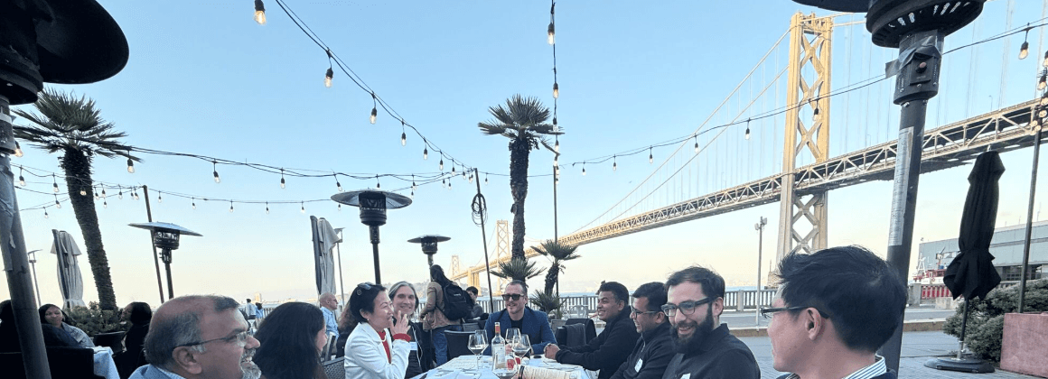 Members at a Tech Leaders dinner on the waterfront, the Bay Bridge behind them